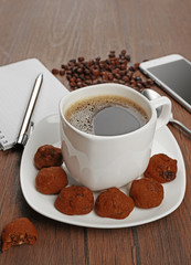 Cup of coffee, phone and notepad  on wooden background
