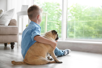 Cute boy with pug dog on floor - Powered by Adobe