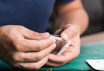 Man repairing broken smartphone, close up photo