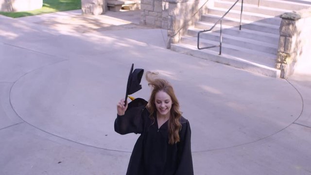 Slow motion girl throwing her gradution cap in the air