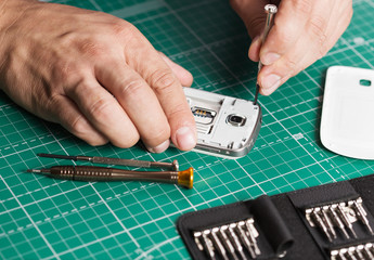 Man repairing broken smartphone, close up photo
