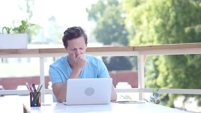 Yawning Tired Designer at Work, Sitting Outdoor