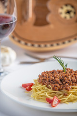 Italian food spaghetti Bolognese on white plate Oud in the background - menu shoot