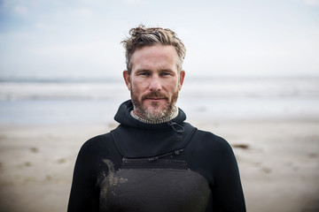 Portrait of confident surfer standing at beach