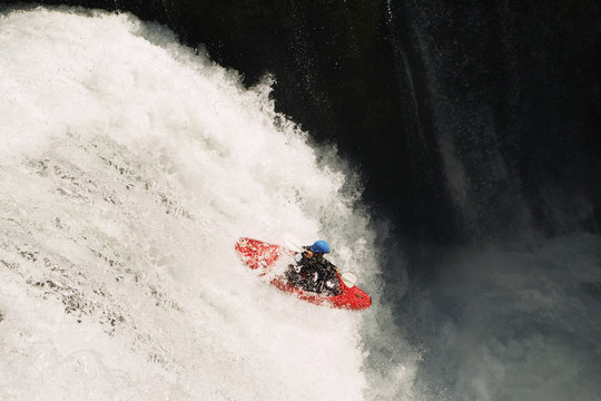 Kayaker descending from waterfall