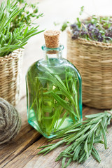Bottle of essential rosemary oil or infusion and basket