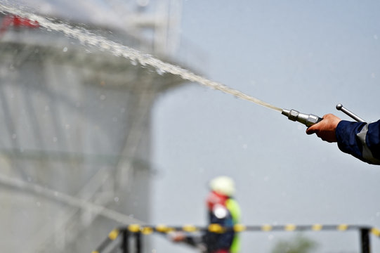 Firefighter holding high pressure water hose