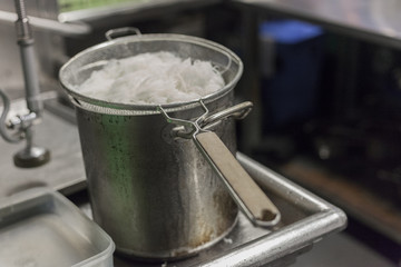 Noodles cool over ice bath. 