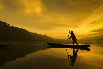 Asia silhouette fishermen on boat fishing at Tambalingan Lake, Bali Indonesia