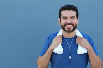 Smiling fitness man holding towel  isolated on a blue background with copy space 