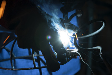 Welder welding with power tool, protective gloves