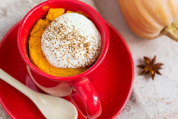 Autumn dessert of pumpkin baked in a cup, top view