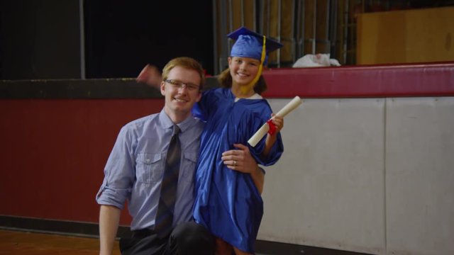 Teacher with young girl graduating with diploma