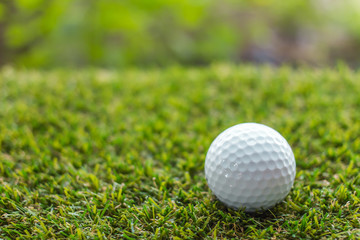 Golf ball on green grass background