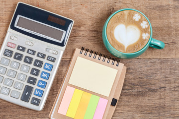 calculator  and cup of coffee on wood