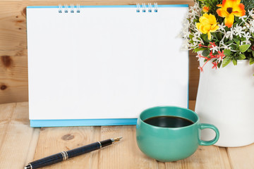 Blank calendar with cup and vase on wood
