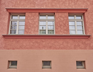 three windows row on colorful house wall