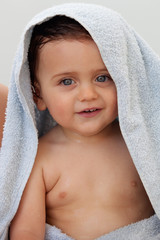 Beautiful baby with blue towel outside