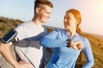 Runner woman with heart rate monitor running on beach