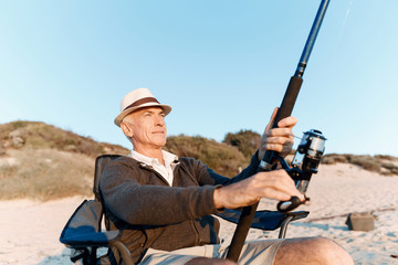 Senior man fishing at sea side