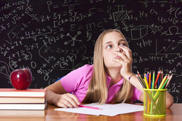 girl studying at the desk with blackboard background