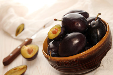 Organic homegrown plums in ceramic bowl