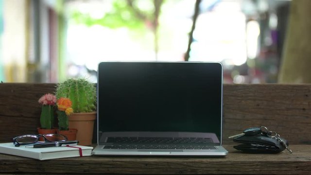 Wood desk with a laptop ,Outdoor workplace under big tree.