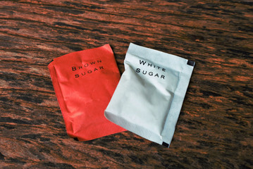 white and brown sugar bag on wood.