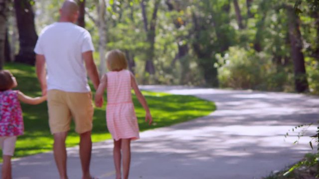 Father walking with two daughters in the park