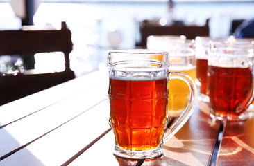 Glass mug of beer on wooden table