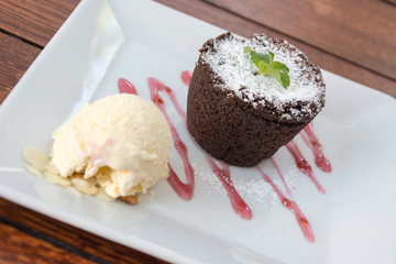 fondant with ice cream on plate on wooden table