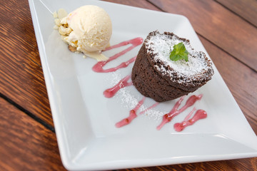 fondant with ice cream on plate on wooden table