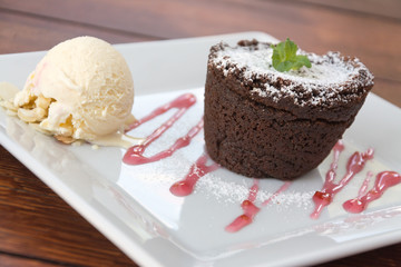 fondant with ice cream on plate on wooden table