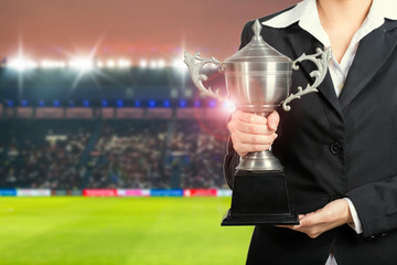 Soccer manager team holding trophy champions in the stadium.