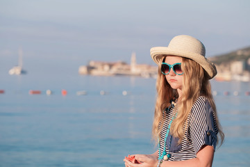 Teen girl with starfish  standing on the beach