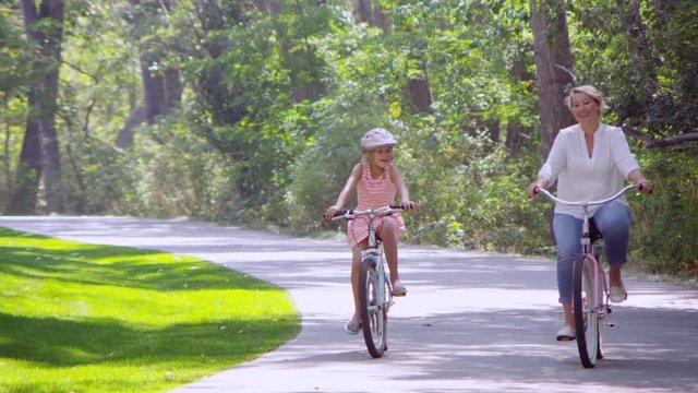Mom riding bicycle with daughter