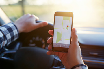 Male hand holding mobile phone with gps map