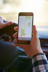 Male hand holding black mobile phone with gps map