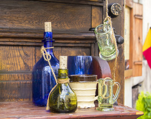 background old glass colored tableware alchemist on vintage wooden shelf in Tallinn