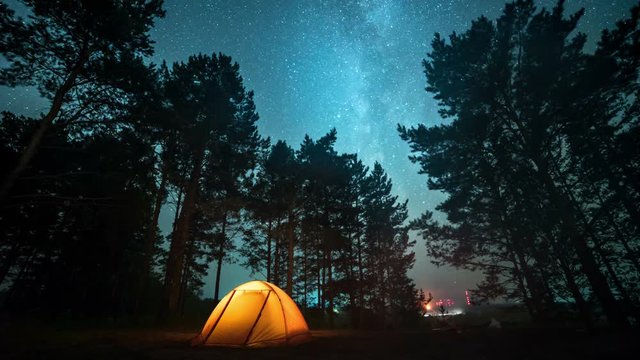 Moving milky way above tent at night time lapse