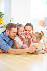Mutter, Vater und Kinder spielen mit Tablet PC