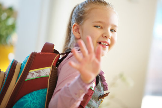 Kind geht zur Schule und winkt zum Abschied
