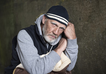 Portrait image of a mature man looking upset and worried on a stone background 