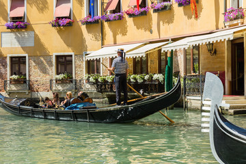 Fototapeta na wymiar Gondolier rides gondola.
