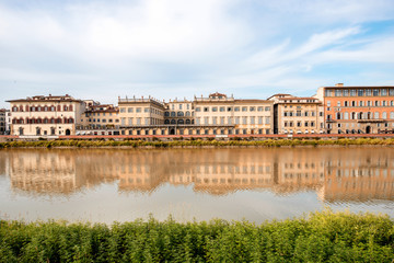 Fototapeta na wymiar Cityscape view on the riverside with the old buildings and palaces near Holy Trinity bridge in Florence