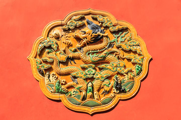 Ancient dragon carved in the red walls of the Forbidden City,in Beijing,China
