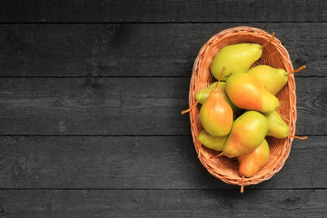 Obraz na płótnie Canvas Pears in a basket on wooden background