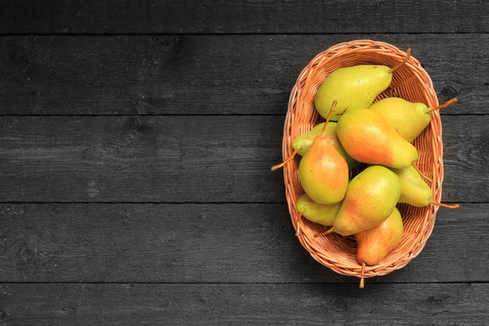 Pears in a basket on wooden background