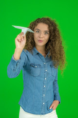 The young woman launch the paper plane the green background