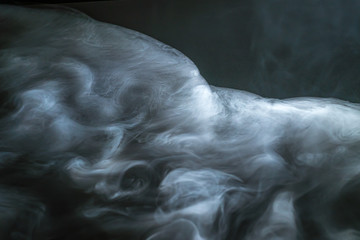 The stream of thick fume on a dark background
